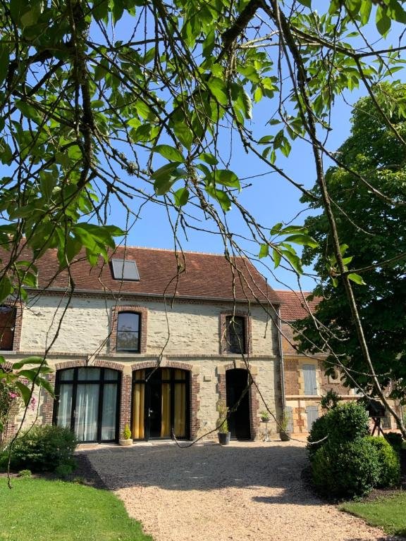 Façade de La Grange des Loges vue depuis l'allée verdoyante